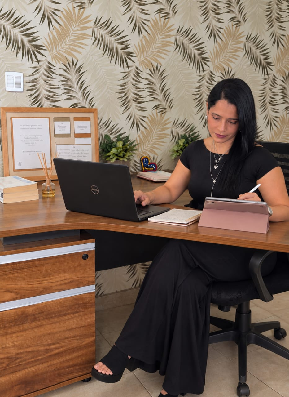 Duvinuska organizando su trabajo con computadora, agenda y tablet